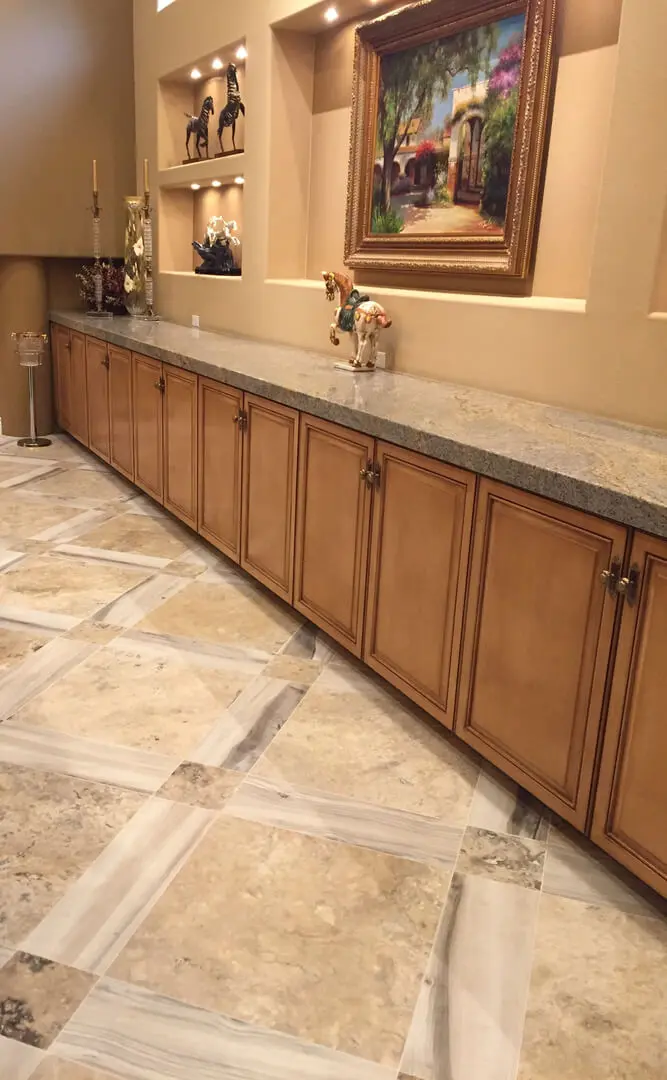 A large kitchen with marble counter tops and tile floor.