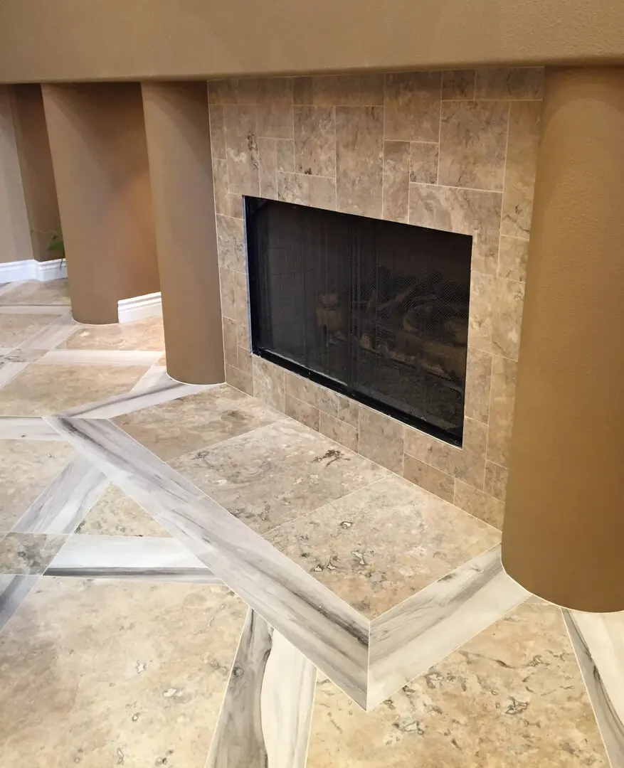 A fireplace in the corner of a room with marble floors.