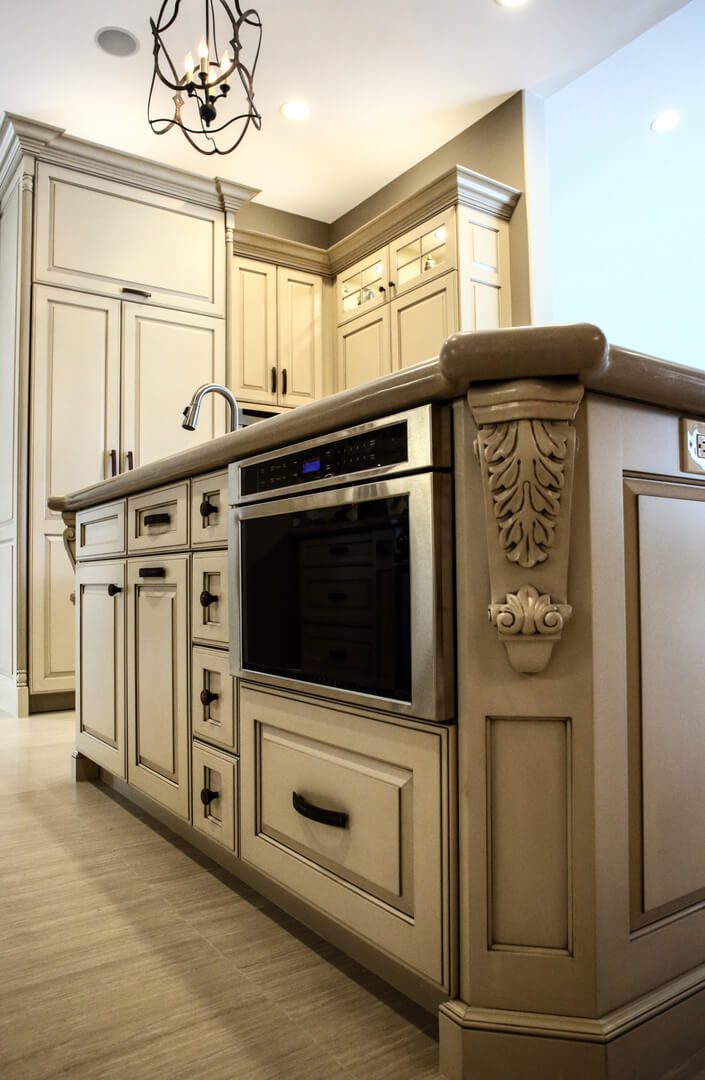 A kitchen with white cabinets and beige walls.
