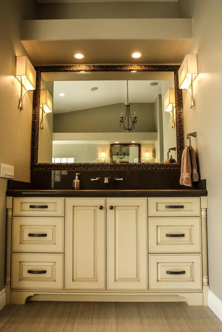 A bathroom with a large mirror and cabinets