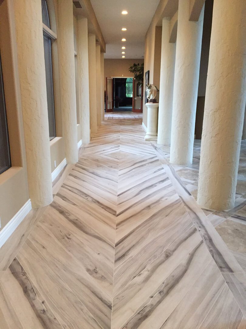 A hallway with pillars and wood floors in it