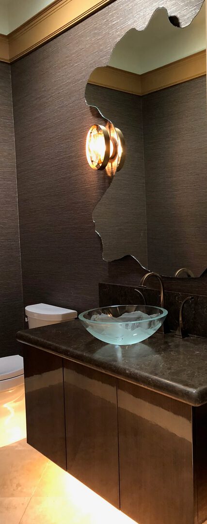 A bowl of water on the counter in front of a mirror.