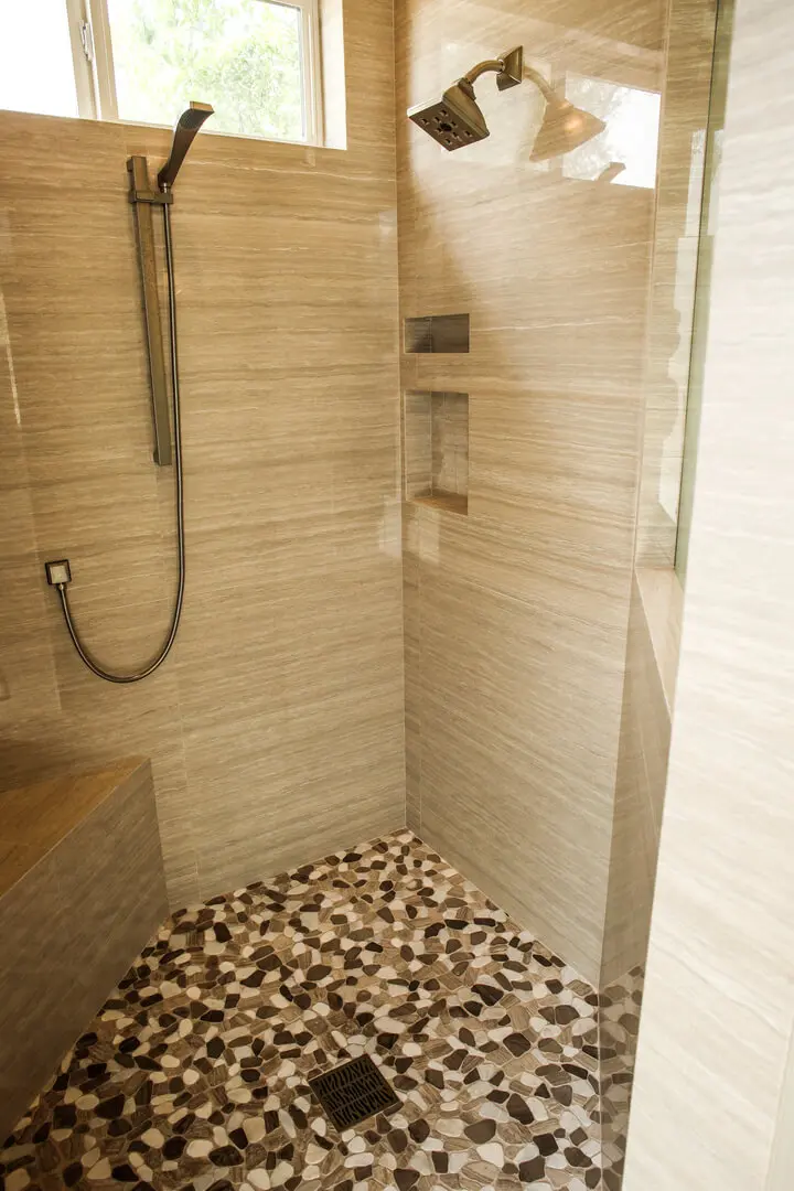 A bathroom with a shower and tiled floor.