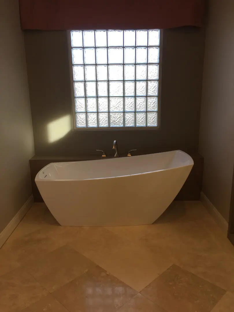 A bathroom with a large tub and tile floor.