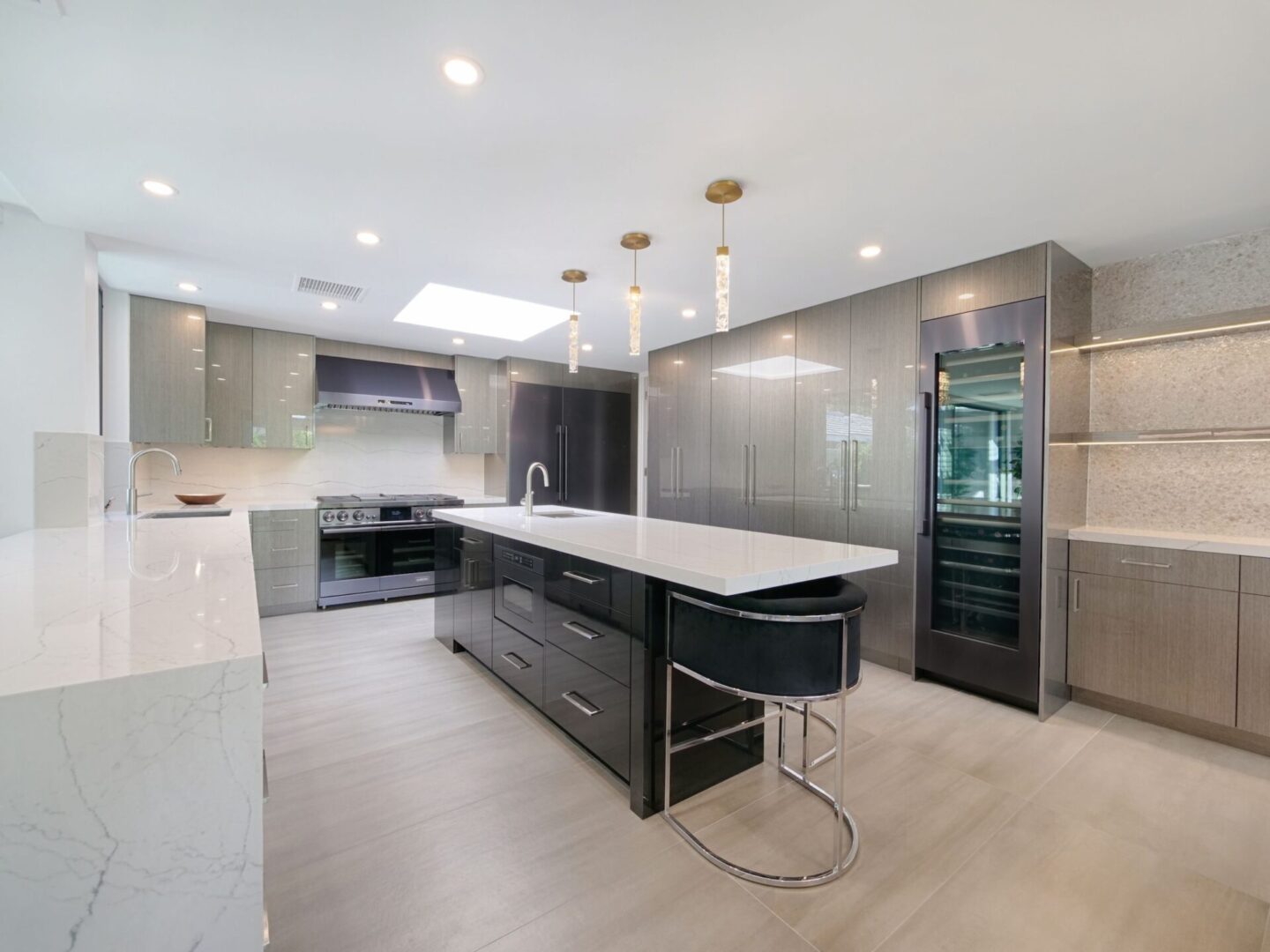 A kitchen with stainless steel cabinets and white counters.