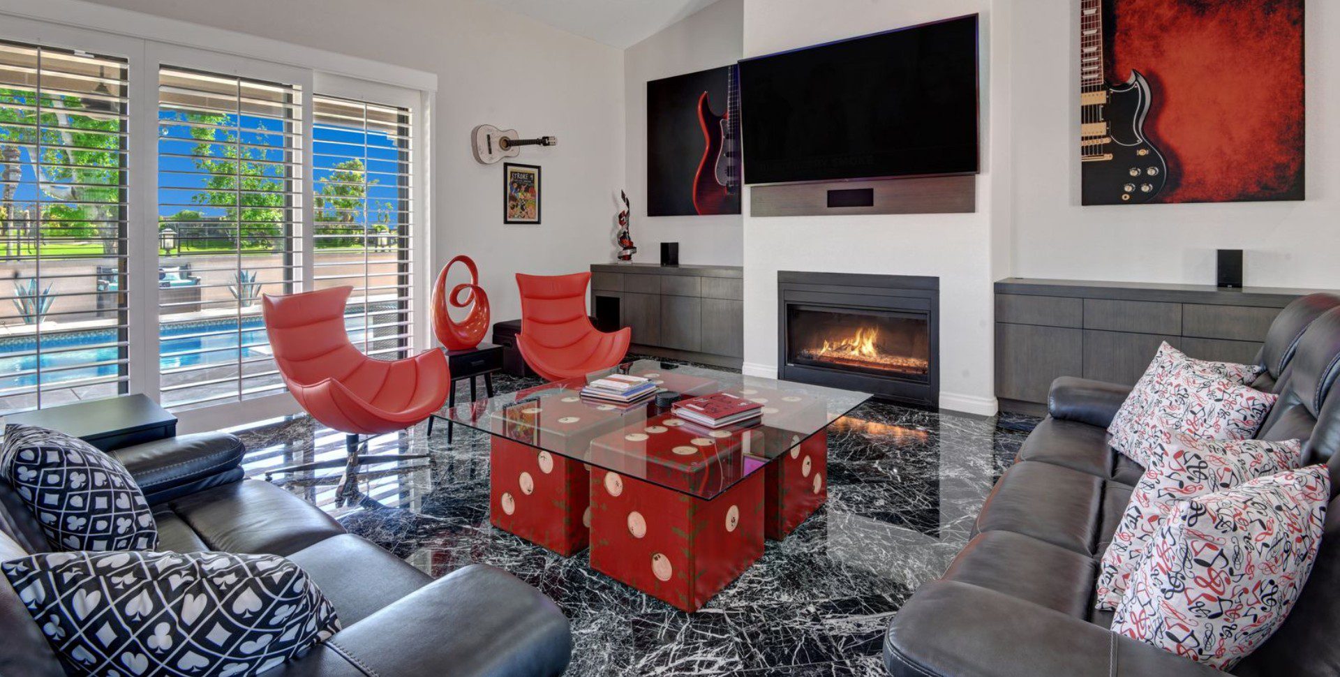 A living room with red chairs and a fire place