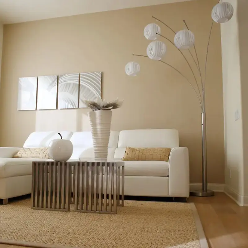 A living room with white furniture and beige walls.