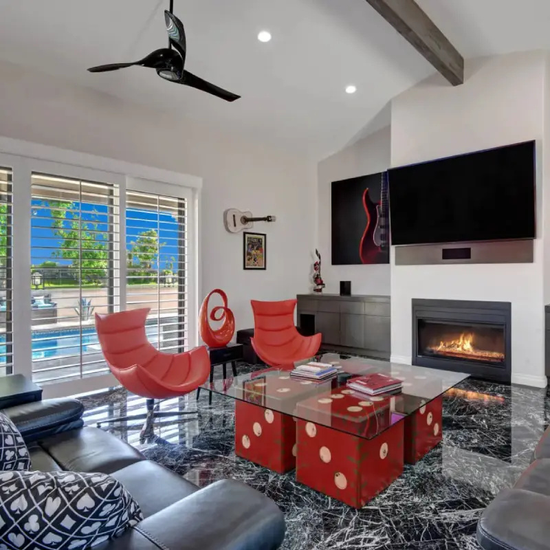 A living room with red chairs and a fire place